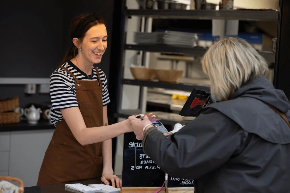 A cashier handing a customer change.